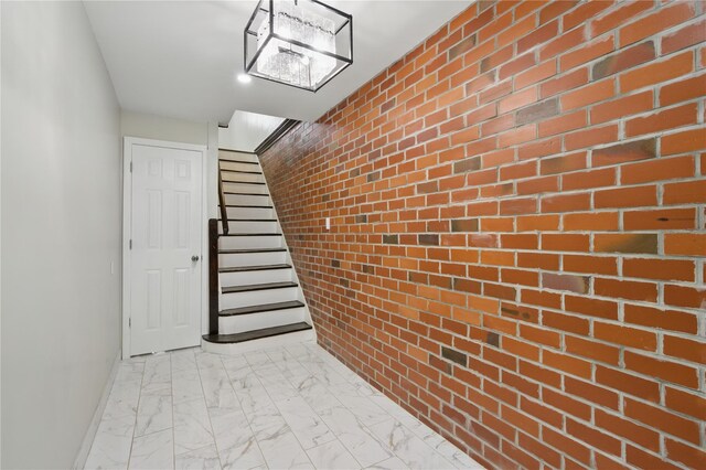 234 Quincy Ave, Bronx, NY 10465 - hallway with brick wall, light marble finish floors, baseboards, and stairs