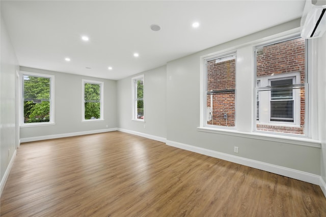 234 Quincy Ave, Bronx, NY 10465 - spare room featuring a wall unit AC, baseboards, wood finished floors, and recessed lighting