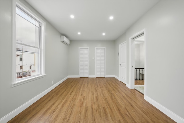 234 Quincy Ave, Bronx, NY 10465 - unfurnished bedroom featuring a wall mounted AC, light wood-style floors, recessed lighting, and baseboards