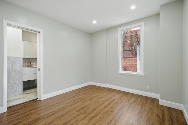 234 Quincy Ave, Bronx, NY 10465 - unfurnished bedroom with wood finished floors, baseboards, recessed lighting, a sink, and multiple windows