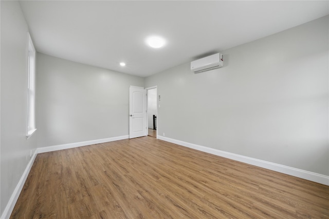 234 Quincy Ave, Bronx, NY 10465 - empty room featuring a wall unit AC, baseboards, light wood finished floors, and recessed lighting