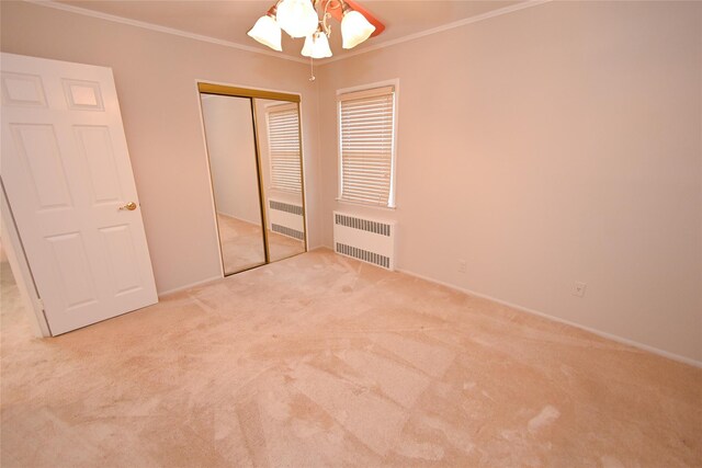 unfurnished bedroom featuring radiator, carpet flooring, ornamental molding, a closet, and baseboards