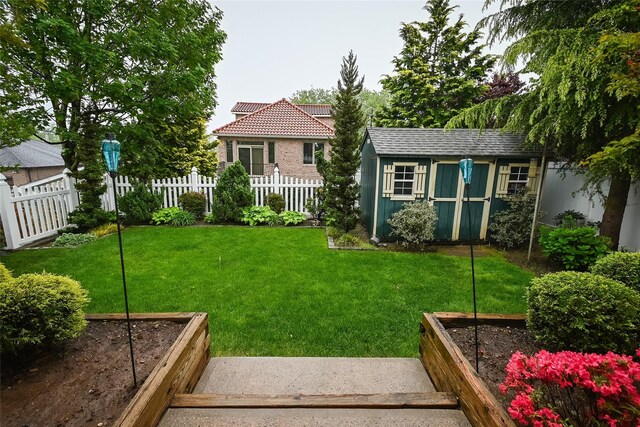 view of yard featuring a garden, a storage shed, and an outdoor structure
