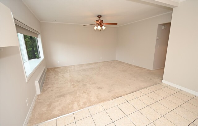 spare room featuring light carpet, ceiling fan, and crown molding