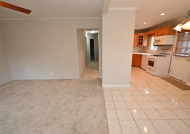 kitchen with white appliances, ornamental molding, a sink, glass insert cabinets, and light countertops