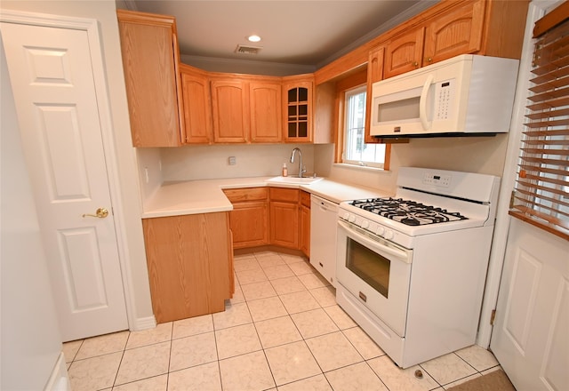 kitchen featuring white appliances, a sink, light tile patterned floors, glass insert cabinets, and recessed lighting
