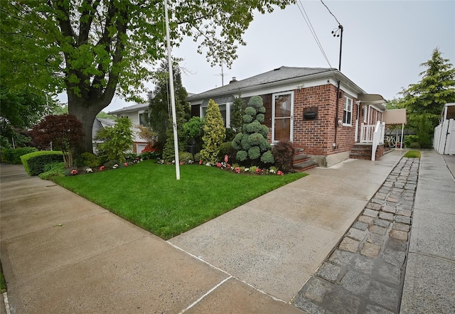 view of front of house featuring brick siding, a front lawn, and concrete driveway