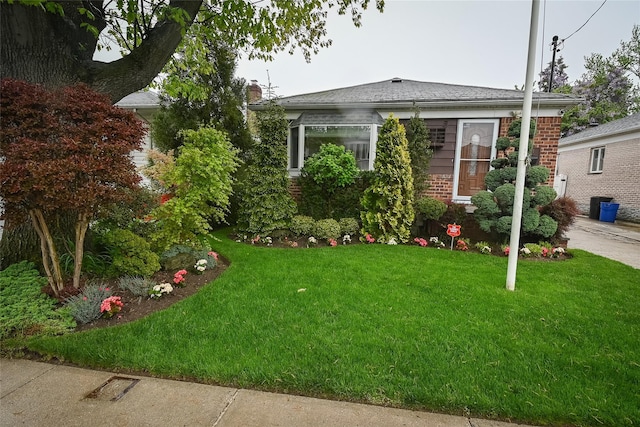 view of front facade featuring brick siding and a front lawn