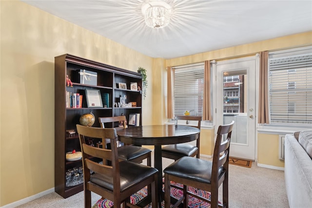 711 Shore Rd Unit 4F, Long Beach, NY 11561 - dining room featuring light carpet, baseboards, and a chandelier
