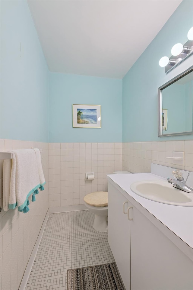 711 Shore Rd Unit 4F, Long Beach, NY 11561 - bathroom with tile walls, vanity, toilet, tile patterned flooring, and a wainscoted wall