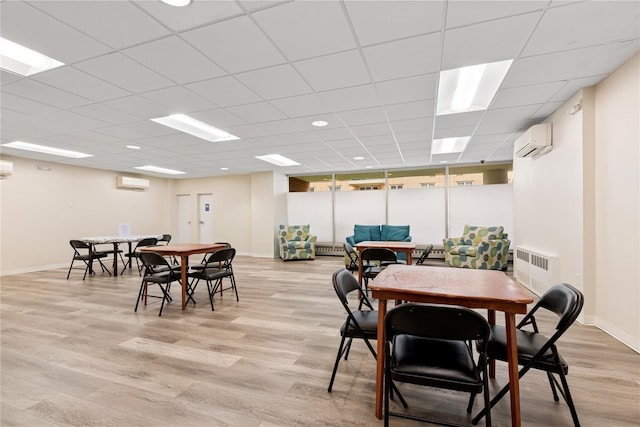 711 Shore Rd Unit 4F, Long Beach, NY 11561 - dining space with a wall unit AC, light wood-style flooring, baseboards, and a paneled ceiling