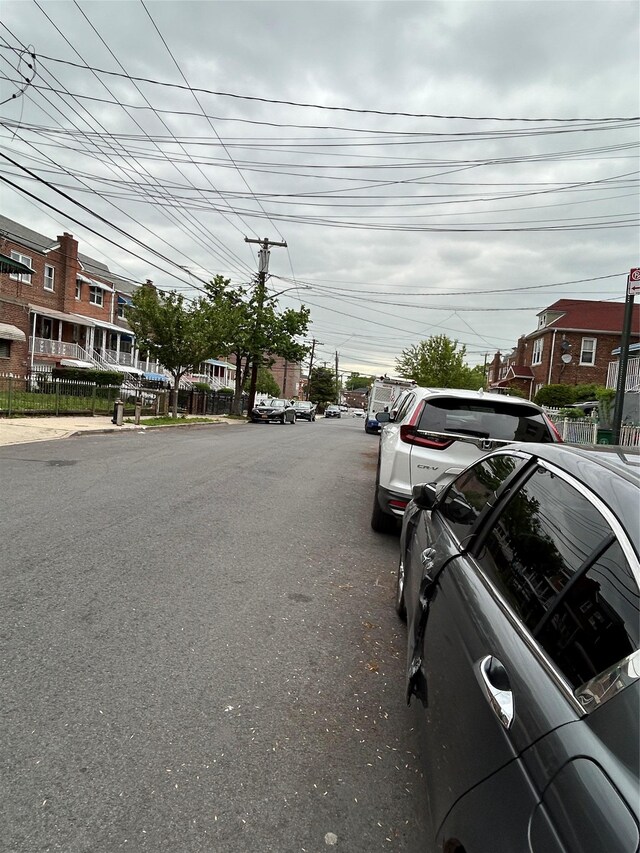view of asphalt road with sidewalks and curbs
