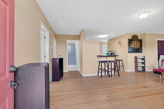 hallway with light wood-type flooring and baseboards