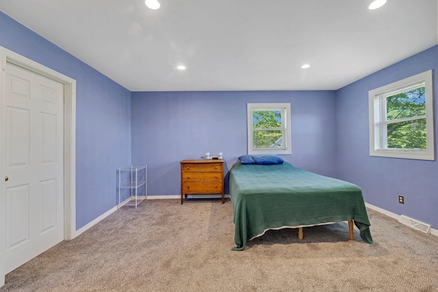 carpeted bedroom with multiple windows, recessed lighting, and baseboards