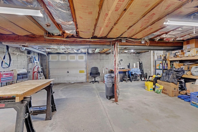 garage with concrete block wall and a workshop area