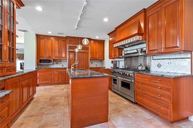 3 Barkers Point Rd, Sands Point, NY 11050 - kitchen featuring high end appliances, custom exhaust hood, a sink, brown cabinetry, and an island with sink