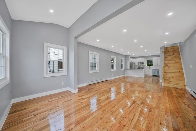 11827 219th St, Cambria Heights, NY 11411 - unfurnished living room featuring baseboard heating, light wood-style floors, baseboards, and recessed lighting