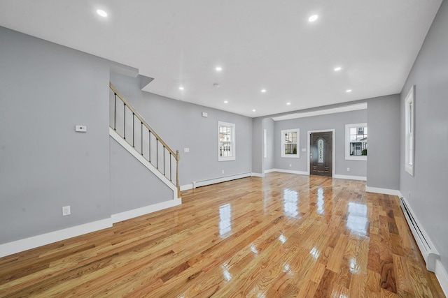 11827 219th St, Cambria Heights, NY 11411 - unfurnished living room with baseboard heating, light wood-type flooring, a baseboard radiator, stairway, and recessed lighting