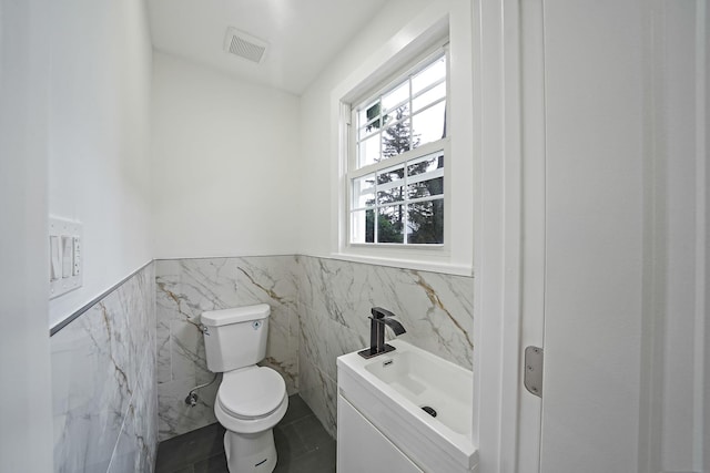 11827 219th St, Cambria Heights, NY 11411 - half bath with tile walls, wainscoting, toilet, tile patterned flooring, and vanity