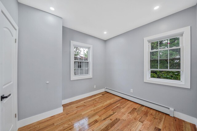 11827 219th St, Cambria Heights, NY 11411 - empty room with baseboard heating, light wood-style flooring, baseboards, and recessed lighting