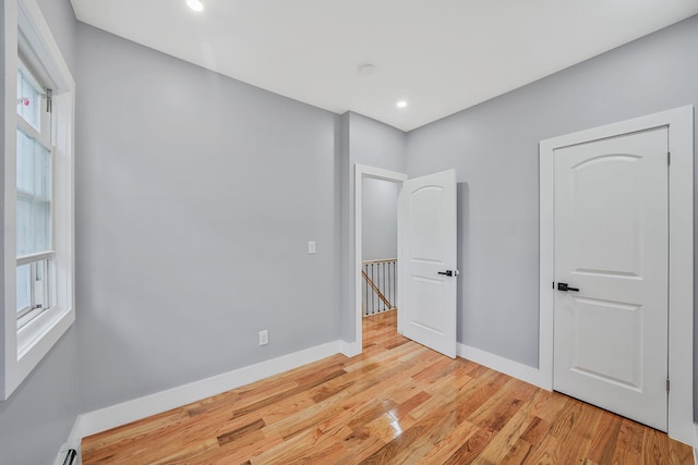 11827 219th St, Cambria Heights, NY 11411 - unfurnished bedroom with light wood-type flooring, baseboards, multiple windows, and recessed lighting