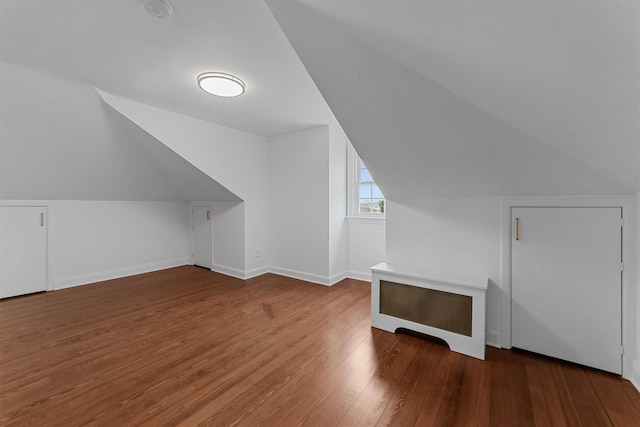 bonus room with wood finished floors, vaulted ceiling, and baseboards
