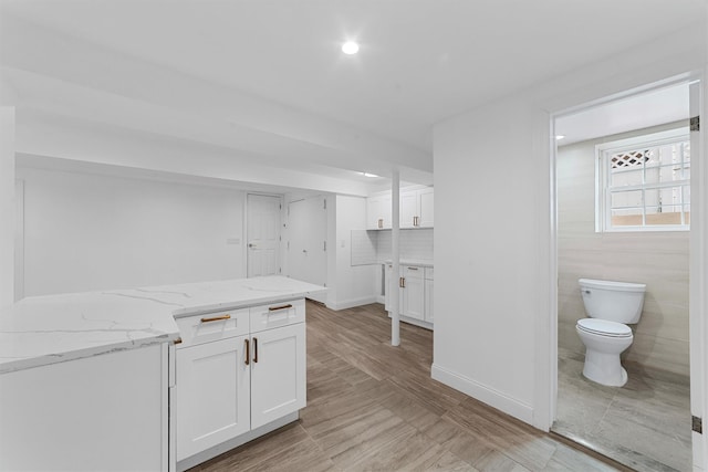 kitchen featuring white cabinetry, light stone countertops, recessed lighting, and backsplash