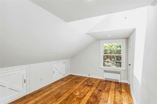 8 Hazel Rd, Port Washington, NY 11050 - bonus room featuring radiator heating unit, hardwood / wood-style floors, and lofted ceiling