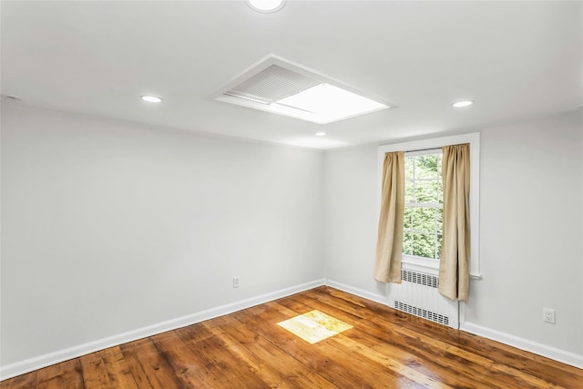8 Hazel Rd, Port Washington, NY 11050 - unfurnished room featuring radiator, hardwood / wood-style floors, recessed lighting, and a skylight