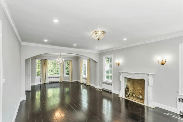 8 Hazel Rd, Port Washington, NY 11050 - unfurnished living room with radiator heating unit, a chandelier, arched walkways, plenty of natural light, and crown molding