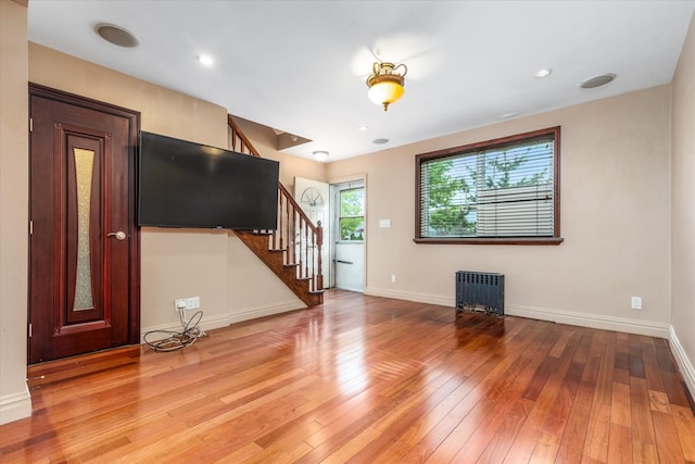 67-15 Bell Blvd Duplex, Unit Duplex, Bayside, NY 11364 - unfurnished living room with radiator heating unit, stairs, light wood finished floors, and baseboards