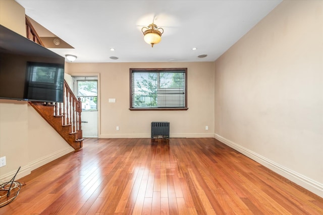 67-15 Bell Blvd Duplex, Unit Duplex, Bayside, NY 11364 - unfurnished living room featuring radiator, hardwood / wood-style flooring, stairway, and baseboards