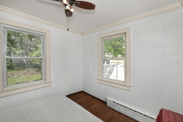 unfurnished room with a baseboard heating unit, plenty of natural light, ceiling fan, and ornamental molding
