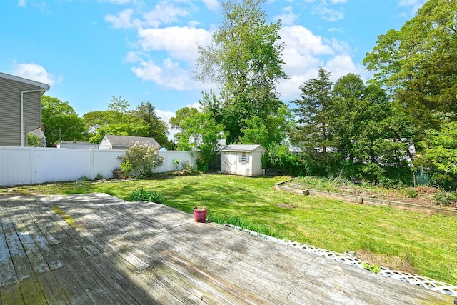 wooden deck featuring a storage shed and an outbuilding