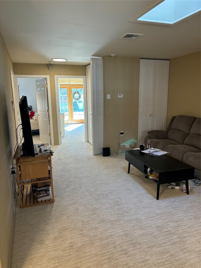living room with light colored carpet and a skylight