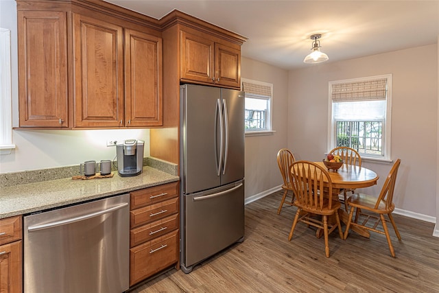 50 Louisiana Ave Unit 9R, Bronxville, NY 10708 - kitchen with stainless steel appliances, brown cabinetry, light wood-style flooring, and baseboards