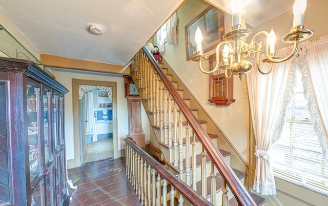 staircase with a chandelier