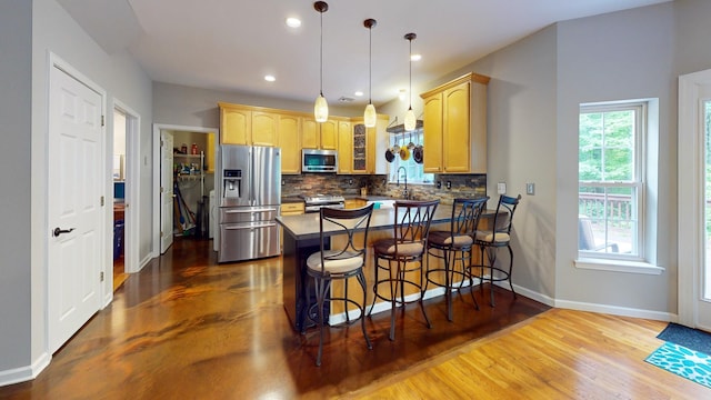 293 S Centerville Rd, Middletown, NY 10940 - kitchen featuring appliances with stainless steel finishes, a peninsula, decorative backsplash, light brown cabinetry, and recessed lighting