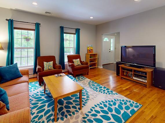 293 S Centerville Rd, Middletown, NY 10940 - living area with healthy amount of natural light, wood finished floors, recessed lighting, and a baseboard radiator