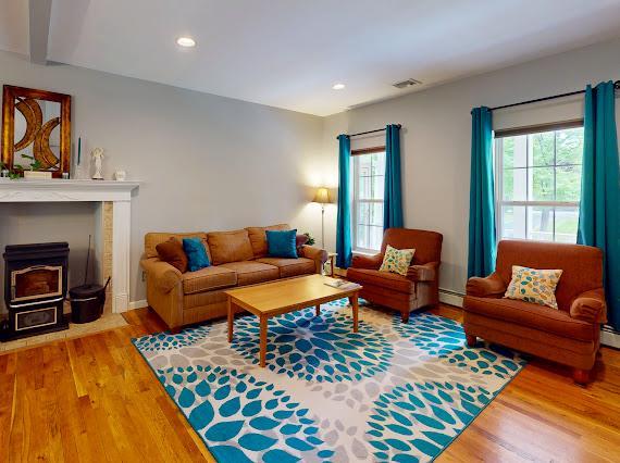 293 S Centerville Rd, Middletown, NY 10940 - living room featuring a baseboard radiator, wood finished floors, recessed lighting, and a wood stove