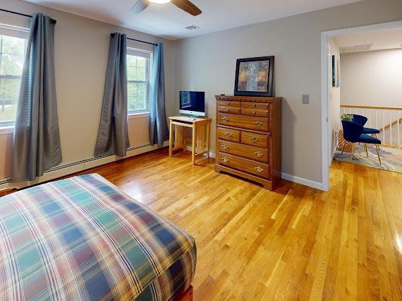 293 S Centerville Rd, Middletown, NY 10940 - bedroom featuring light wood-style floors, baseboard heating, ceiling fan, and baseboards