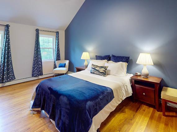 293 S Centerville Rd, Middletown, NY 10940 - bedroom featuring vaulted ceiling, a baseboard heating unit, and wood finished floors
