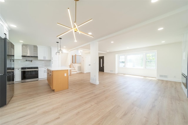 2001 Wellington Ct, Westbury, NY 11590 - kitchen featuring range with electric stovetop, open floor plan, tasteful backsplash, a center island, and light wood-style flooring