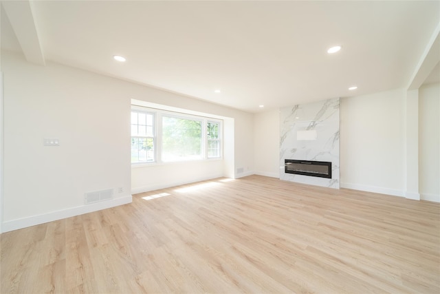 2001 Wellington Ct, Westbury, NY 11590 - unfurnished living room with light wood-style flooring, recessed lighting, baseboards, and a high end fireplace