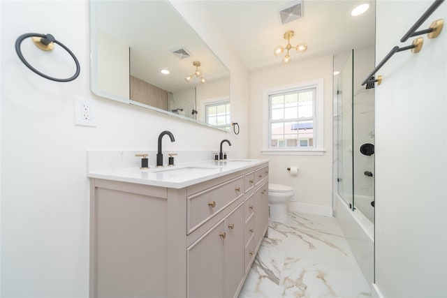 2001 Wellington Ct, Westbury, NY 11590 - bathroom featuring double vanity, baseboards, marble finish flooring, combined bath / shower with glass door, and toilet