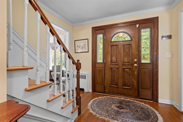 foyer entrance featuring healthy amount of natural light, stairway, wood finished floors, crown molding, and baseboards
