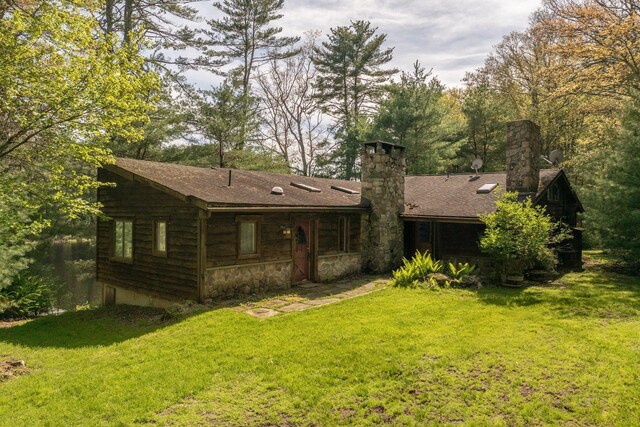62 Stag Forest Rd, Forestburgh, NY 12777 - rear view of house with a chimney, a lawn, stone siding, and roof with shingles