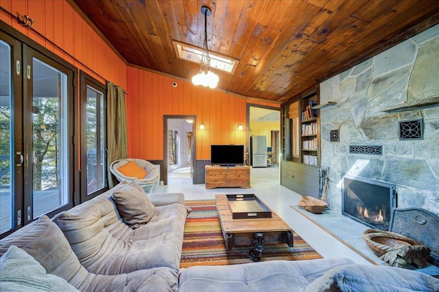 62 Stag Forest Rd, Forestburgh, NY 12777 - living room with wood ceiling, healthy amount of natural light, a stone fireplace, built in shelves, and wood walls