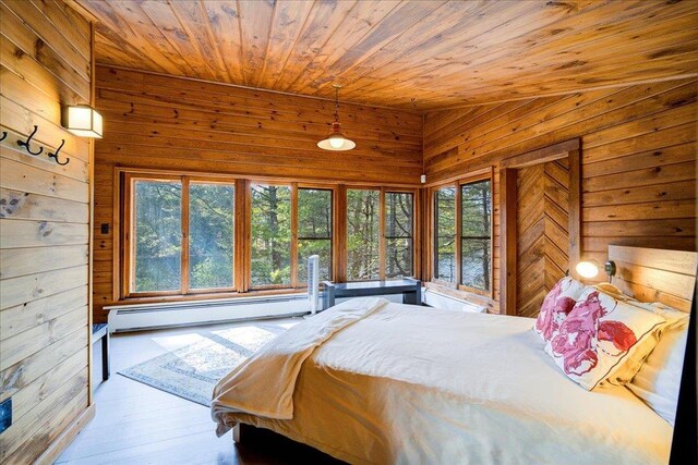 62 Stag Forest Rd, Forestburgh, NY 12777 - bedroom featuring baseboard heating, wood walls, wooden ceiling, multiple windows, and wood finished floors
