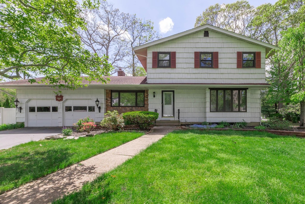 284 Bow Dr, Hauppauge, NY 11788 - view of front of property featuring a garage, driveway, a front yard, and a chimney